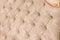 Beige soft tapestry pattern background with symmetrical buttons on the corners of diamonds. Soft and expensive furniture