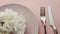 Beige table setting with peony flowers on plate and silverware for luxury dinner party, wedding or birthday celebration