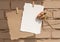 Beige tender tea-rose, brown natural craft and white paper pinned on a rustic rope in front of beige background. Free blank copy