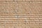 Beige weathered bricks wall in sunlight background