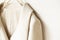 Beige or white jacket hanging on clothes hanger on white background