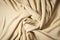 Beige woven textile drape background. Waving cloth fabric canvas