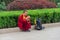 Beijing, China, July 6, 2015, Editorial photo of budhist monk which take a rest on kerb with his phone in his hand, Beijing, Chin