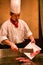 Beijing, China - June 9, 2018: A Chinese chef is cooking dinner in front of the restaurant visitors.