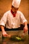 Beijing, China - June 9, 2018: A Chinese chef is cooking dinner in front of the restaurant visitors.