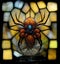 Bejeweled spider embedded on a colorful stained glass