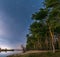 Belarus, Eastern Europe. Night Sky Stars Above Countryside Landscape With Growing Pines Forest On River Coast. Natural