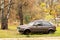 Belarus, Minsk 02 11 2020: Old abandoned beige car without a wheel on the background of autumn nature