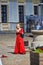 Belarus, Nesvizh August 2019. A girl in an old red dress plays the flute. Folk concert on the square of the old castle