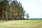 Belarusian landscape. Spring field and forest on sky background