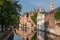 Belfry towers over facades of Groenerei, Bruges, Belgium