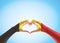 Belgian black yellow red flag pattern on people heart shaped hands clipping path on sky background