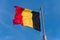 Belgian flag waving against blue sky