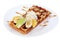 Belgian waffle with condensed milk, whipped cream and fruit.