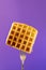 Belgian waffle with honey decorated sweet cherry pinned on a fork