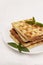 Belgian waffles with fresh mint on a white plate on a white tablecloth, retro toning, close-up