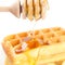 Belgian waffles on a plate, stick for honey and honey