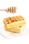 Belgian waffles on a plate, stick for honey and honey