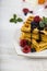Belgian waffles with raspberries, blueberries and mint, covered