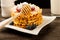 Belgian waffles with raspberries and sieving sugar powder and honey served with jug of milk on a white table