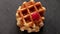 Belgian waffles with raspberries and sugar powder over rusty surface. Flat lay