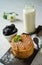 Belgium Dutch waffle cookies and caramel sauce with mint on wooden board and bottle of milk, bowl of blackberries and powdered