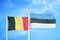 Belgium and Estonia two flags on flagpoles and blue cloudy sky