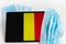 Belgium flag covered by surgical protective mask for coronavirus COVID-19 prevention.