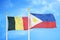 Belgium and Philippines two flags on flagpoles and blue cloudy sky