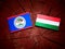 Belize flag with Hungarian flag on a tree stump isolated
