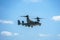 Bell Boeing V-22 Osprey Army helicopter hovering on a blue sky background.