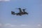 Bell Boeing V-22 Osprey Army helicopter hovering on a blue sky background.