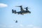 Bell Boeing V-22 Osprey Army helicopter hovering on a blue sky background.