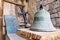 Bell, cross and hammered crucifix on background of masonry and an old wooden shield on handmade rug