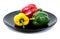 Bell pepers in a plate over white background. Sweet peppers in black dish isolated