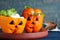 Bell peppers with black olives and lettuce as Halloween monsters on blue wooden table, closeup