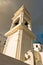 Bell tower and a blue dome of a church at sunset, Imerovigli village, Santorini island