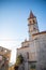 Bell tower of the Church of Our Lady of the Annunciation at the end of a narrow street in the town of Milna on Brac