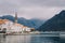 Bell tower of the church of St. Nicholas above the red tiled roofs of the houses of Perast against the backdrop of the