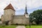The bell tower of the Church of St. Nicholas appears behind the towers and medieval walls of the Old Town of Tallinn, Estonia