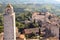 Bell tower on cityscape of San Gimignano, Tuscany town with brick towers and old houses. Italian province.