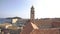 The bell tower of the Dominican monastery on the background of modern Dubrovnik, Croatia.