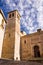 Bell tower and facade of a church in the historic center of Toledo with an Islamic-style door