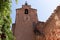 Bell tower of fortress with clock and red ochre stone wall Roussillon in Provence France