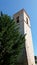 Bell tower next to a high pine tree