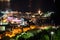 Bell tower of the Old Town of Budva city and Ricardova Glava beach at night time. Aerial view with houses roofs. Adriatic sea.