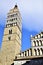 Bell tower and part of the cathedral of San Zeno framed illuminated by the sun and framed by the blue sky veiled by light clouds,