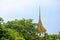 A bell tower in a temple Is covered by green trees