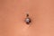 Belly piercing in the navel close up