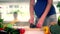 Belly of pregnant woman and hands sharpen kitchen knife on table